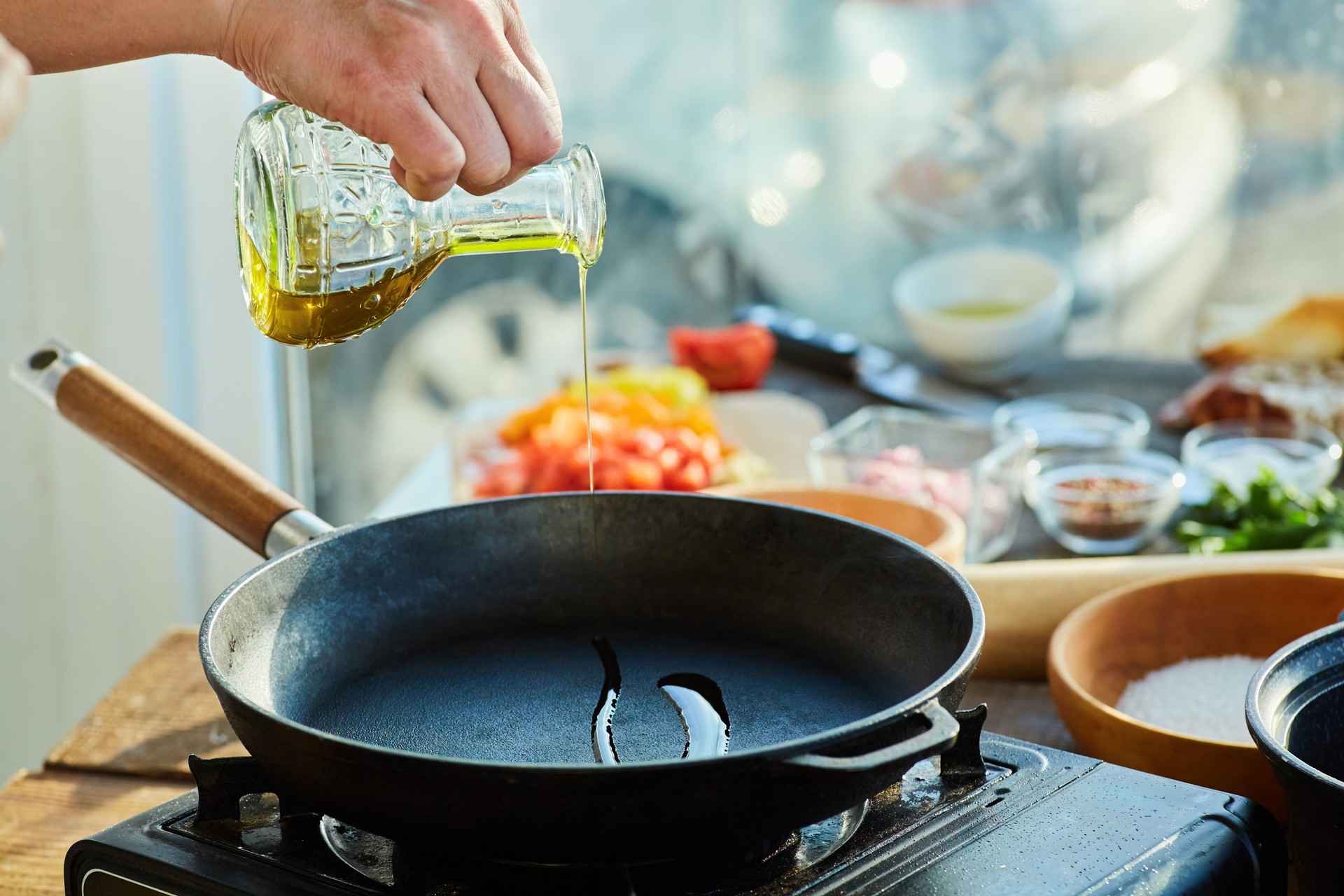 Chef Igor pouring cold-pressed olive oil into a pan — healthy cooking fats include olive oil, coconut oil, lard, and tallow, never seed oils